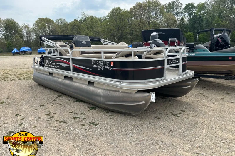 The Image of 2017 Sun Tracker Bass Buggy 18 DLX pontoon boat parked on gravel lot. - 0