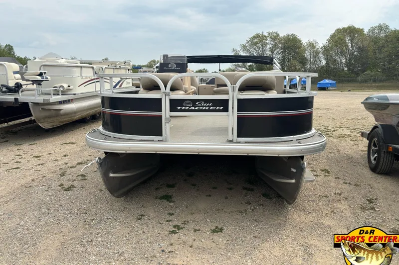 Slide: The Image of 2017 Sun Tracker Bass Buggy 18 DLX pontoon boat parked on gravel lot. - 3