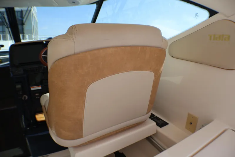 Slide: The Image of Captain's seat in 2009 Tiara Yachts 3500 Sovran, featuring beige upholstery and helm view. - 11