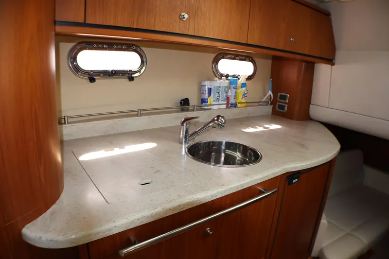 Slide: The Image of 2009 Tiara Yachts 3500 Sovran galley with wooden cabinetry and stainless steel sink. - 14