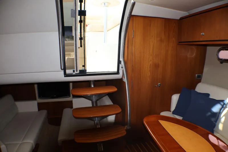 Slide: The Image of Interior of 2009 Tiara Yachts 3500 Sovran, featuring wooden stairs and cozy seating area. - 17