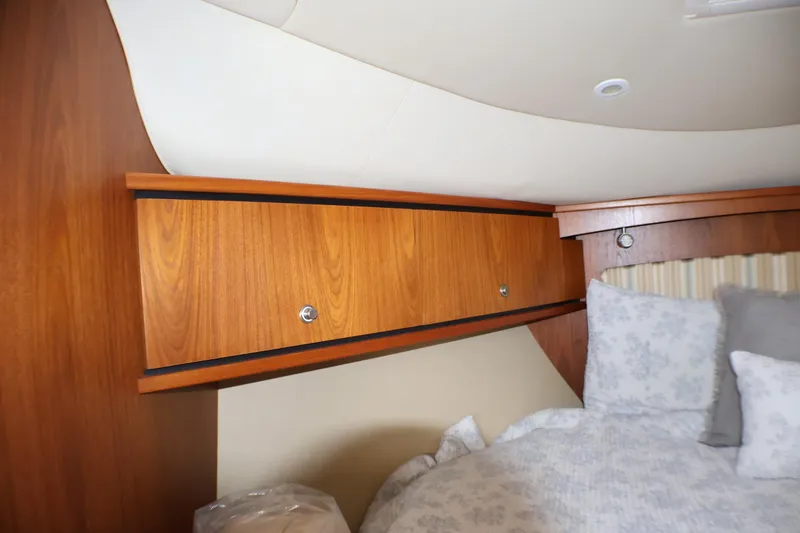 Slide: The Image of 2009 Tiara Yachts 3500 Sovran cabin with wooden storage and cozy bedding. - 22