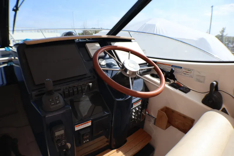 Slide: The Image of 2009 Tiara Yachts 3500 Sovran helm with wooden steering wheel and navigation controls. - 5