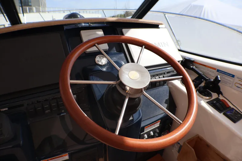 Slide: The Image of Steering wheel of 2009 Tiara Yachts 3500 Sovran, featuring a sleek wooden design. - 6