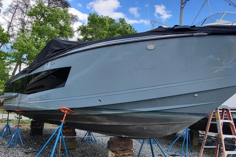 The Image of 2023 Aviara AV32 OB boat on stands, covered, with trees and sky background. - 0