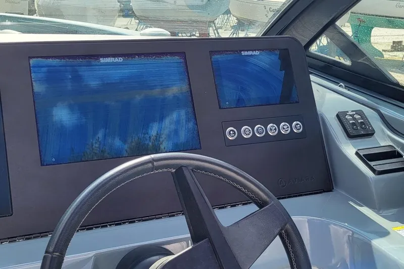 Slide: The Image of 2023 Aviara AV32 OB boat dashboard with Simrad displays and steering wheel. - 16