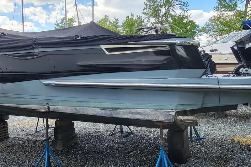 Slide: The Image of 2023 Aviara AV32 OB boat on stands, covered, in a marina setting. - 2