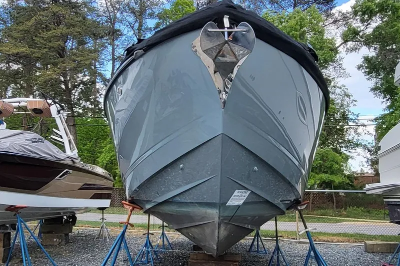 Slide: The Image of 2023 Aviara AV32 OB boat on stands, surrounded by trees and other boats. - 3