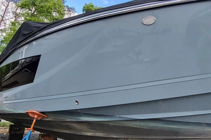 Slide: The Image of 2023 Aviara AV32 OB boat hull with sleek design, parked outdoors. - 4