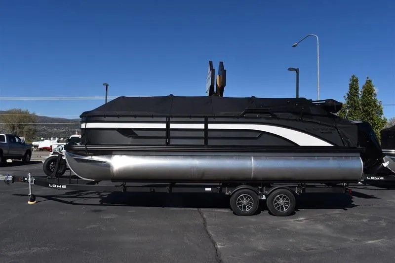 The Image of 2026 Lowe SF 232 WT Sport Fish pontoon boat on trailer, covered and parked outdoors. - 0