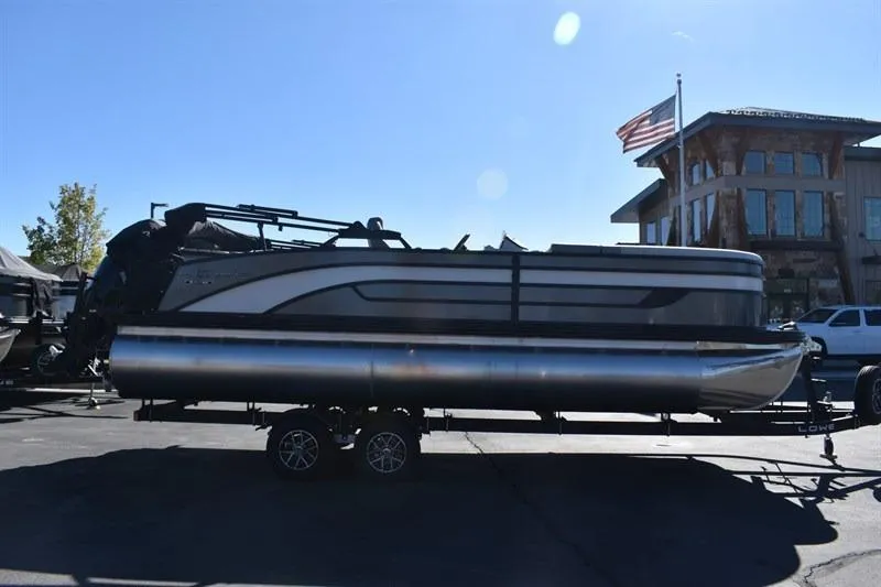 Slide: The Image of 2026 Lowe SF 232 WT Sport Fish pontoon boat on trailer, parked outdoors. - 10