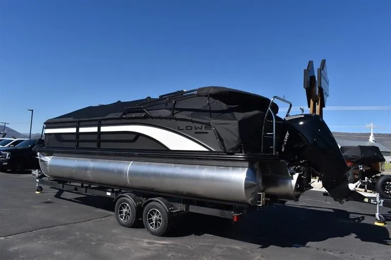 Slide: The Image of 2026 Lowe SF 232 WT Sport Fish pontoon boat on trailer, covered and parked outdoors. - 2