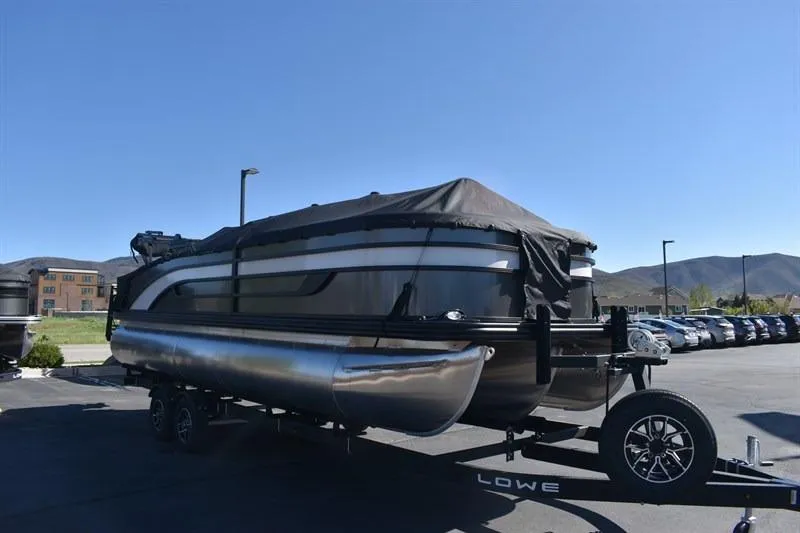 Slide: The Image of 2026 Lowe SF 232 WT Sport Fish pontoon boat on trailer, covered, in parking lot. - 5