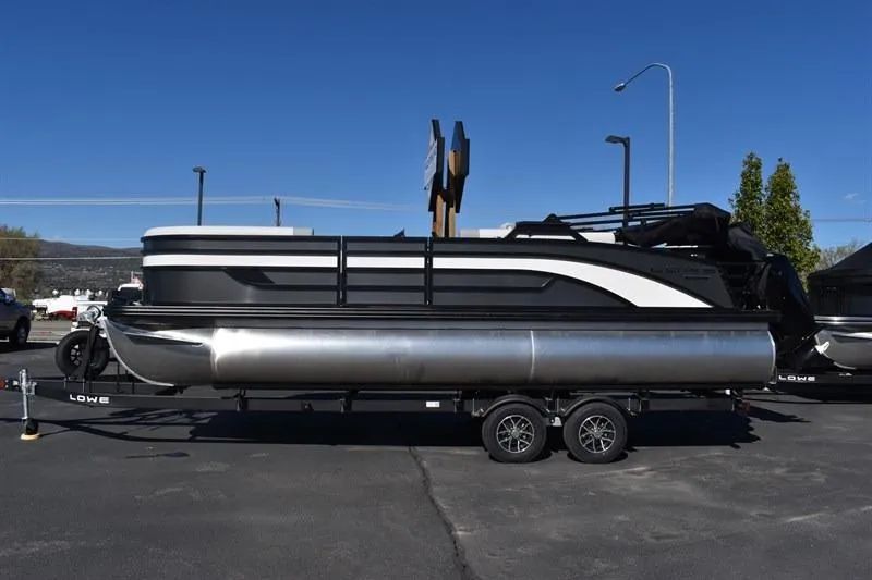 Slide: The Image of 2026 Lowe SF 232 WT Sport Fish pontoon boat on trailer, parked outdoors. - 7