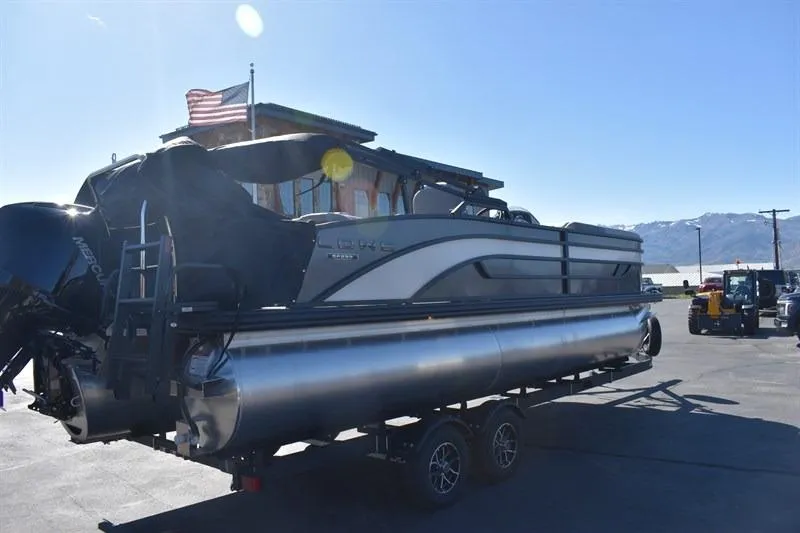 Slide: The Image of 2026 Lowe SF 232 WT Sport Fish pontoon boat on trailer, parked outdoors. - 9