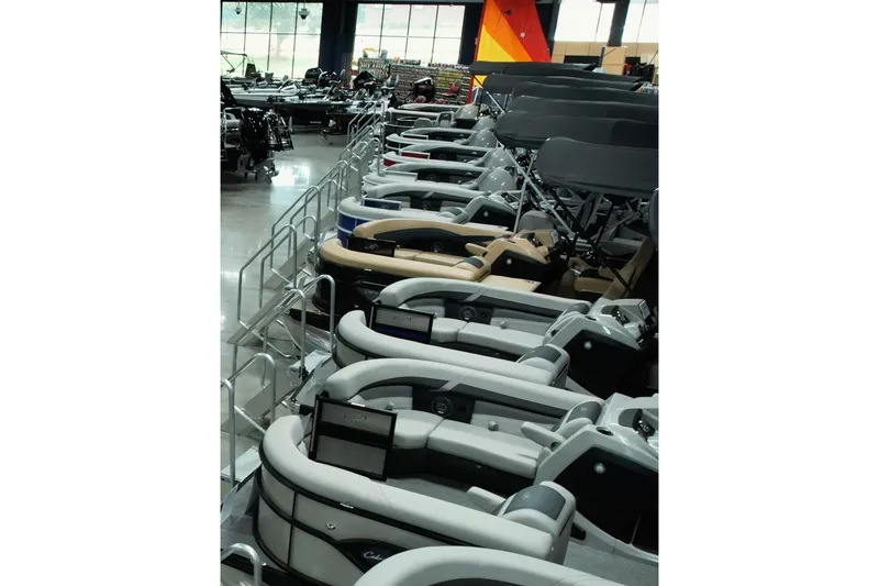 Slide: The Image of 2024 Barletta C22UC pontoon boats displayed in a showroom. - 10