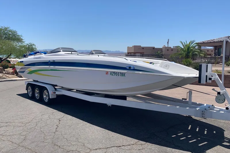 The Image of 2006 Conquest 28 Top Cat II boat on trailer, parked outdoors under clear blue sky. - 0