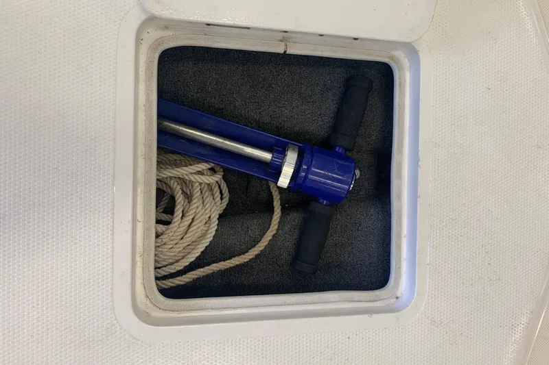 Slide: The Image of Storage compartment on a 2006 Conquest 28 Top Cat II with rope and blue tool. - 12