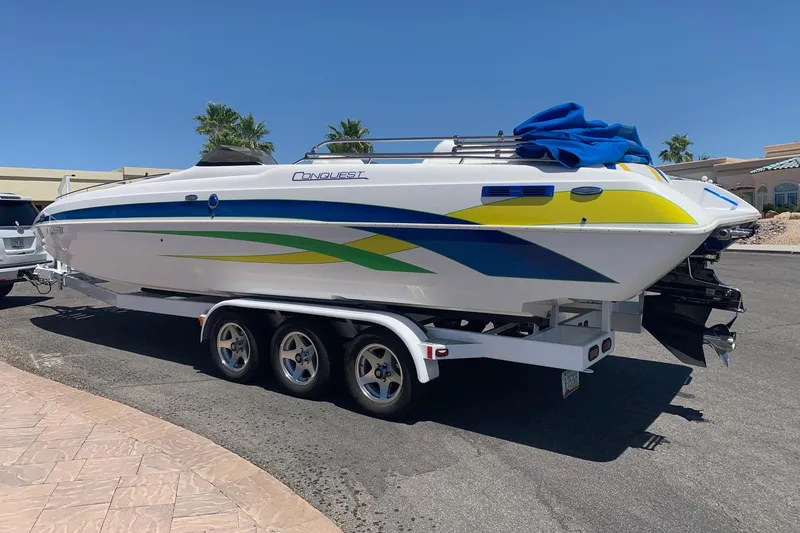Slide: The Image of 2006 Conquest 28 Top Cat II boat on trailer, vibrant graphics, sunny day. - 2