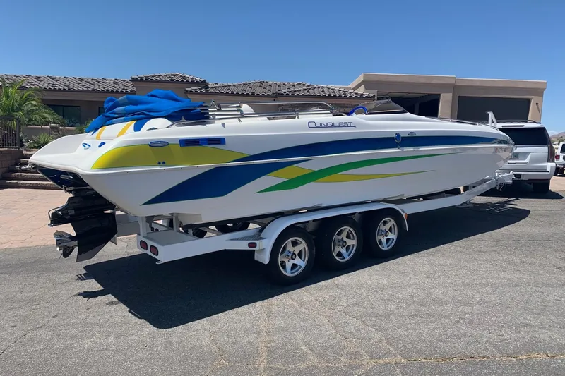 Slide: The Image of 2006 Conquest 28 Top Cat II boat on trailer, vibrant graphics, parked outdoors. - 3