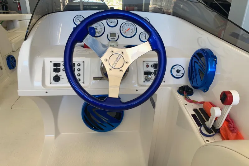 Slide: The Image of 2006 Conquest 28 Top Cat II boat dashboard with blue steering wheel and gauges. - 5