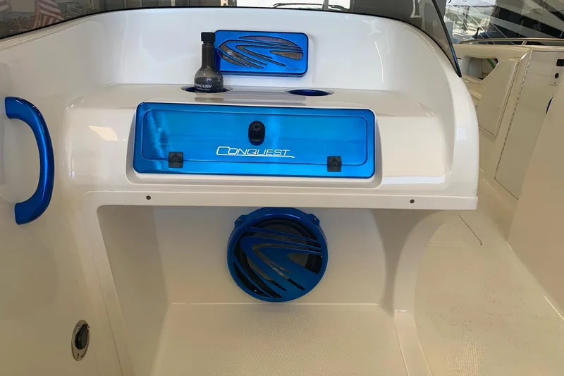 Slide: The Image of 2006 Conquest 28 Top Cat II boat interior with blue accents and storage compartments. - 8