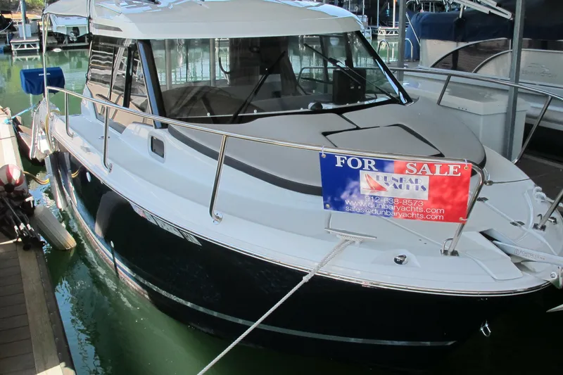 The Image of 2020 Jeanneau NC 795 boat for sale, docked with a sales banner displayed. - 0