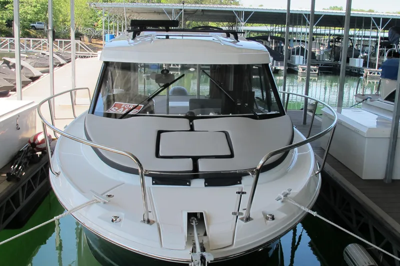 Slide: The Image of 2020 Jeanneau NC 795 boat docked, front view, with "For Sale" sign. - 2