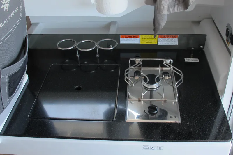 Slide: The Image of Compact kitchen area on 2020 Jeanneau NC 795 boat with stove and sink. - 23