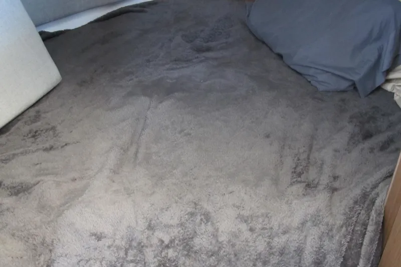 Slide: The Image of Cozy bed with gray blanket in 2020 Jeanneau NC 795 cabin. - 24