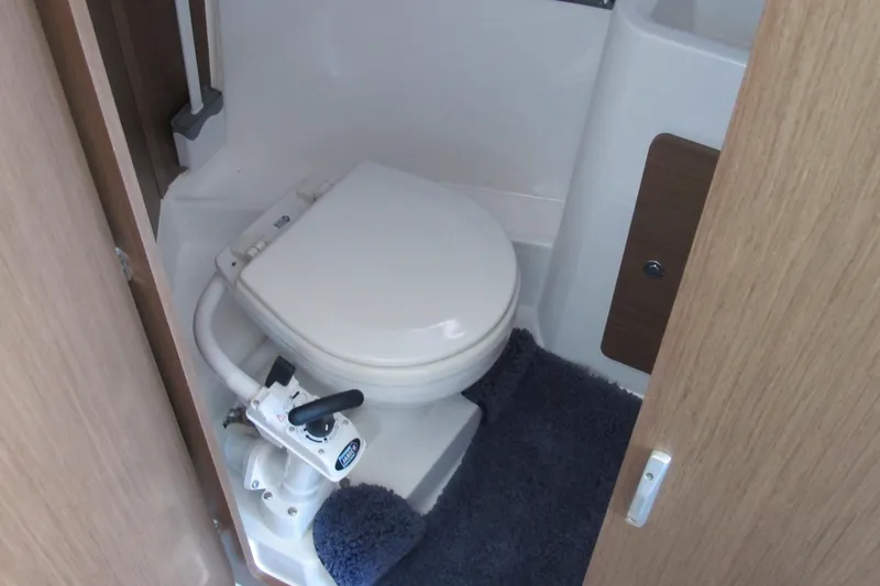Slide: The Image of 2020 Jeanneau NC 795 boat bathroom with marine toilet and blue rug. - 25