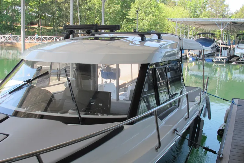 Slide: The Image of 2020 Jeanneau NC 795 boat docked in a marina with lush greenery. - 3