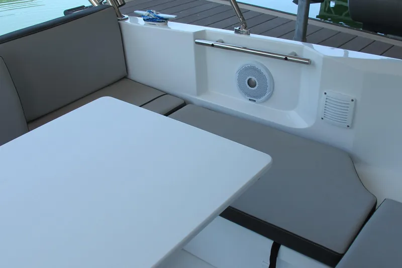 Slide: The Image of Interior seating area of 2020 Jeanneau NC 795 boat with table and speaker. - 9