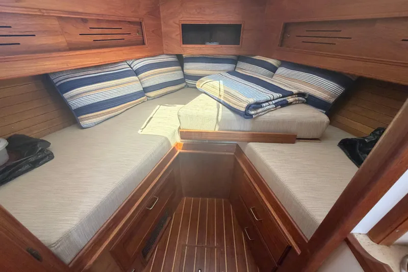 Slide: The Image of Cozy cabin interior of 1990 Cape Dory 28 Flybridge with striped cushions and wooden finish. - 1