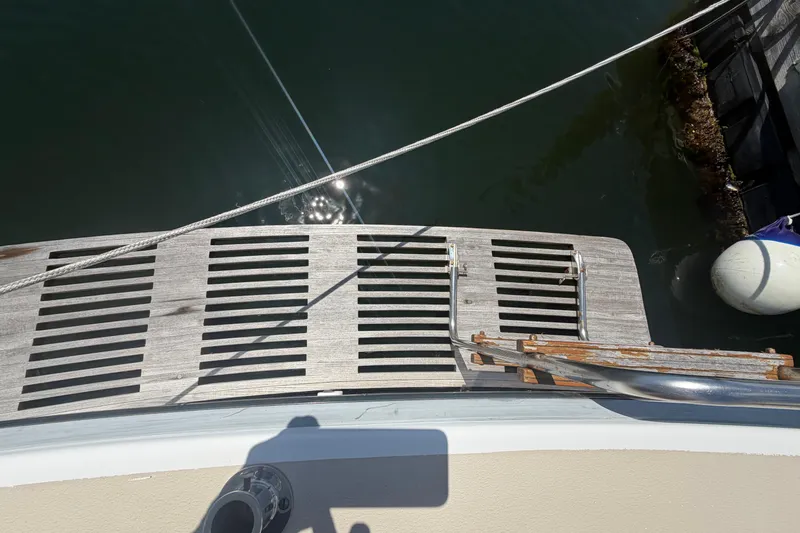 Slide: The Image of Stern view of 1990 Cape Dory 28 Flybridge with wooden swim platform and ladder. - 11