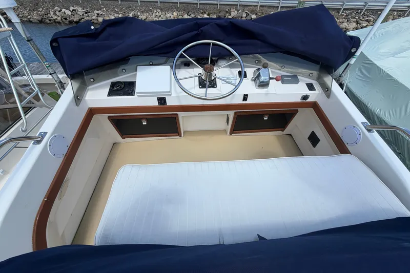 Slide: The Image of 1990 Cape Dory 28 Flybridge helm with steering wheel and navigation controls. - 13