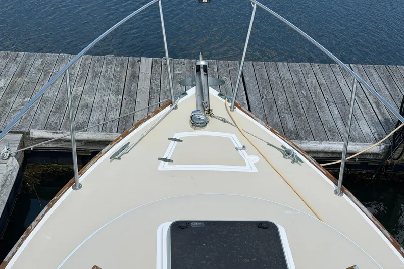 Slide: The Image of Bow of 1990 Cape Dory 28 Flybridge docked at a wooden pier. - 14