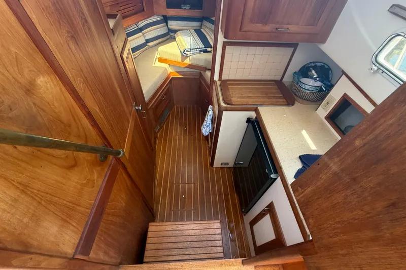 Slide: The Image of Interior of 1990 Cape Dory 28 Flybridge with wood finish and compact kitchen area. - 3