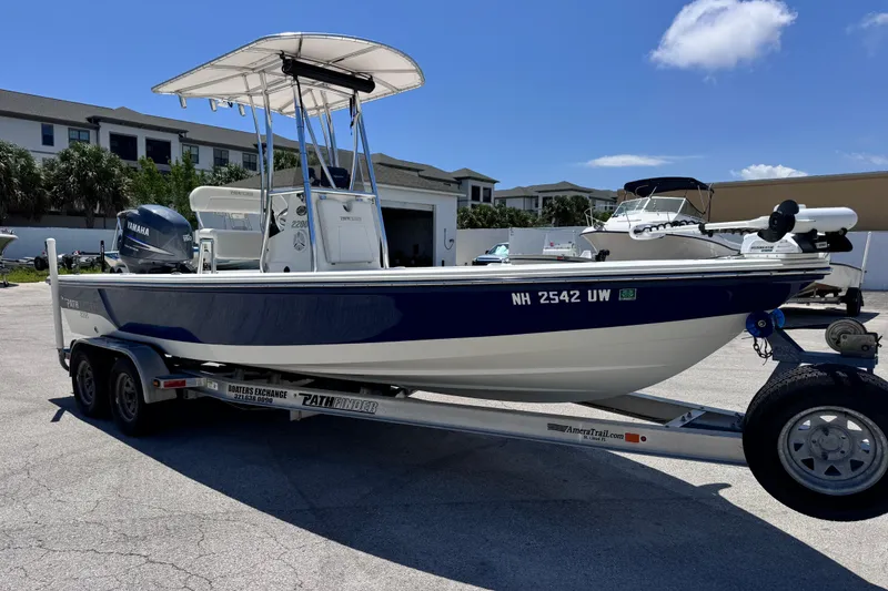 Slide: The Image of 2012 Pathfinder 2200 TRS boat on trailer, parked outdoors under clear sky. - 10