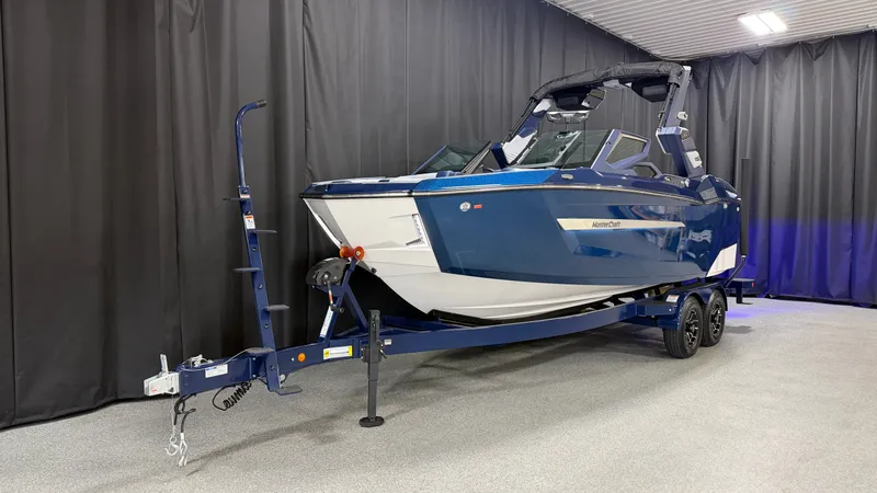 Slide: The Image of 2027 MasterCraft XT23 on trailer in showroom. - 2