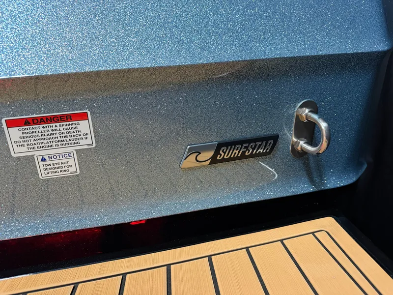 Slide: The Image of Close-up of a 2027 MasterCraft XT23's stern with SurfStar logo and warning labels. - 11