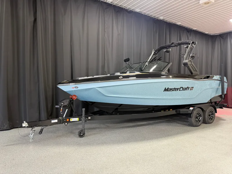 Slide: The Image of A 2027 MasterCraft XT23 boat on a trailer in a showroom setting. - 3