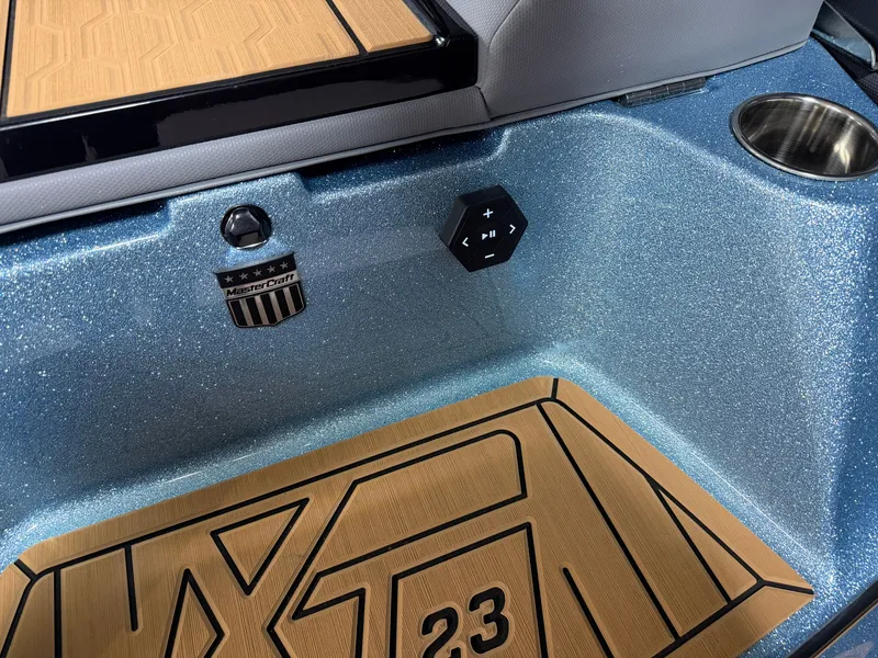Slide: The Image of Close-up of a 2027 MasterCraft XT23 interior with sparkling blue finish and wood flooring. - 17