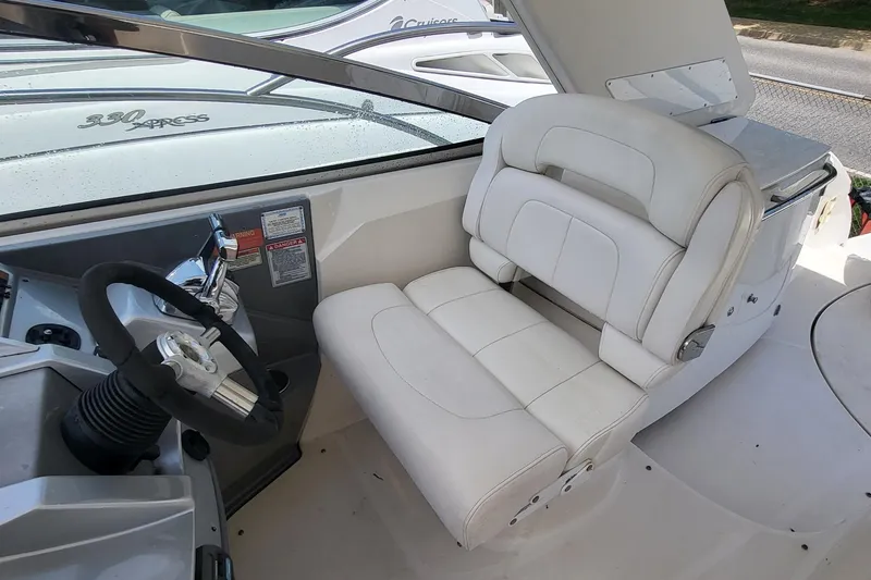 Slide: The Image of Captain's seat and helm of a 2008 Monterey 350 Sport Yacht, featuring white upholstery. - 10