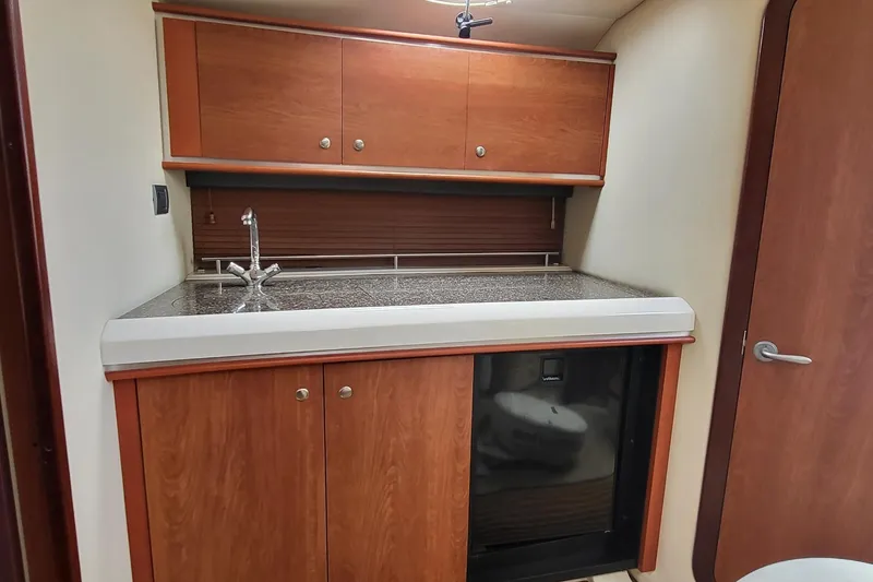 Slide: The Image of 2008 Monterey 350 Sport Yacht interior kitchenette with wood cabinets and compact sink. - 19