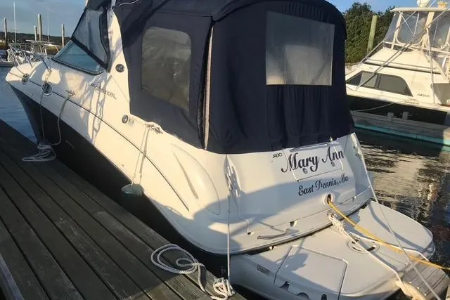 Slide: The Image of 2004 Sea Ray Sundancer 280 docked, featuring a navy canopy and sleek white hull. - 3