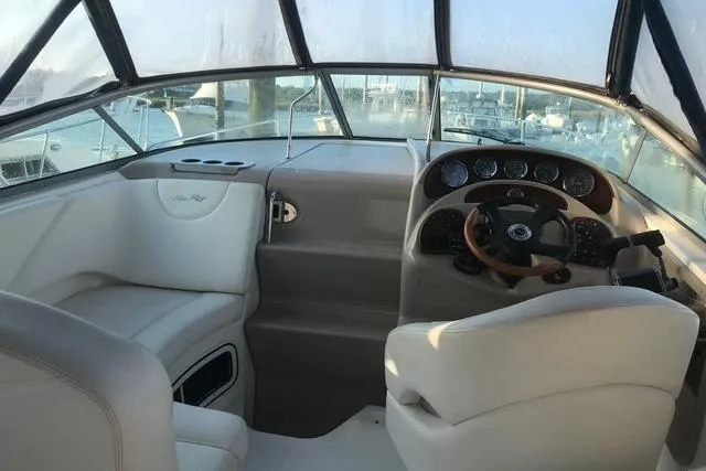 Slide: The Image of 2004 Sea Ray Sundancer 280 helm with leather seating and wooden steering wheel. - 5