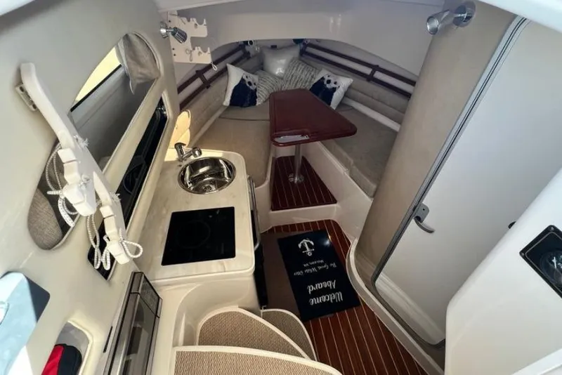 Slide: The Image of 2017 Grady-White Marlin 300 cabin interior with kitchenette and seating area. - 10