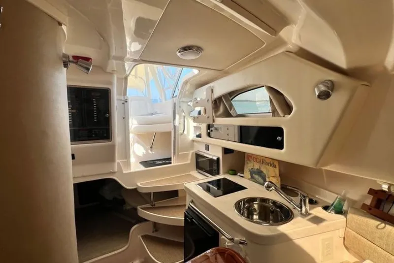 Slide: The Image of 2017 Grady-White Marlin 300 cabin interior with kitchenette and seating area. - 11