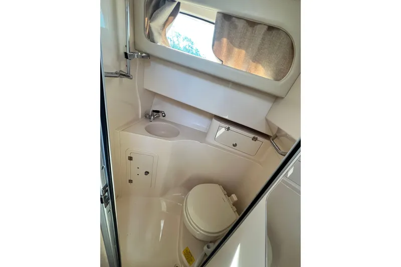 Slide: The Image of 2017 Grady-White Marlin 300 boat bathroom with sink, toilet, and window. - 12